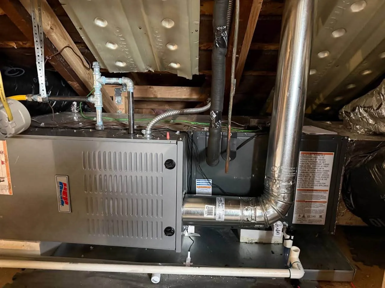 Furnace with flue pipe installed under wooden floor joists